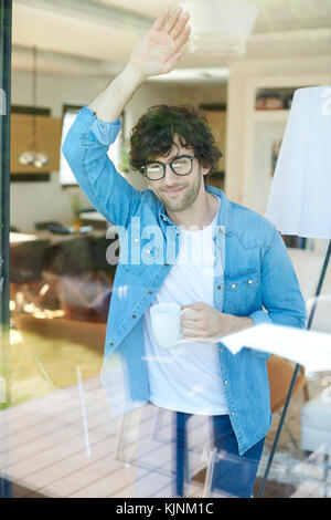 Schuss eines Mannes, der eine Tasse Kaffee in der Hand hält. Stockfoto