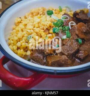 Typisch Ungarisches Rindergulasch serviert in einem Emaille Teller mit Zwiebel und spetzles. Quadratischen Format. Stockfoto