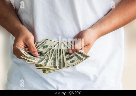 Ein Mann mit amerikanischen Hundert-Euro-Scheine vor ihm. Stockfoto