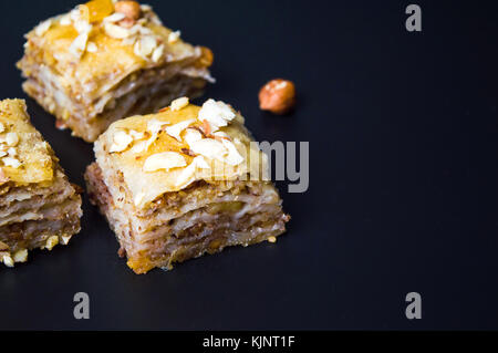 Baklava dessert Schichten mit Muttern auf dunklem Hintergrund Stockfoto