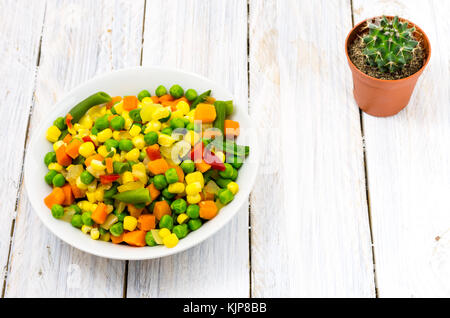Weiße Platte mit gemischter Salat. Weiß Holz- Hintergrund. Stockfoto