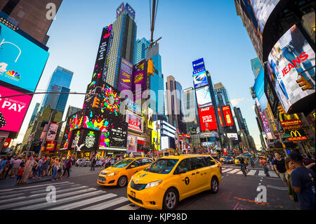 NEW YORK CITY - 23. AUGUST 2017: Helles Neon signage blinkt über Massen und taxi Verkehr Zoomen durch den Times Square. Stockfoto