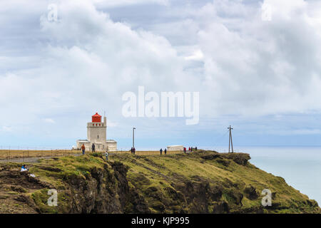 VIK i MYRDAL, ISLAND - 9. SEPTEMBER 2017: Touristen auf einer Klippe in der Nähe des Leuchtturms Vik (Dyrholaeyjarviti) auf der Halbinsel Dyrholaey, in der Nähe des Dorfes Vik i Myrdal Stockfoto