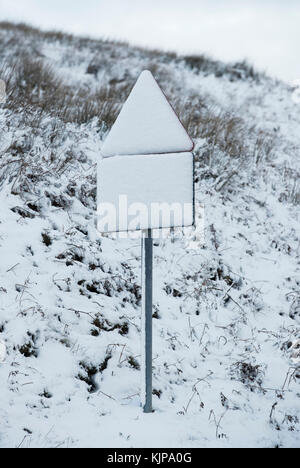 Ein mit Schnee bedecktes Straßenschild auf dem Buttertubs Pass im Yorkshire Dales National Park, da das kalte und winterliche Wetter ansetzen wird. Stockfoto