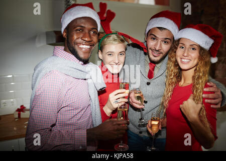 Zwei junge Paare in den xmas Hüte genießen Partei und in Champagner Stockfoto