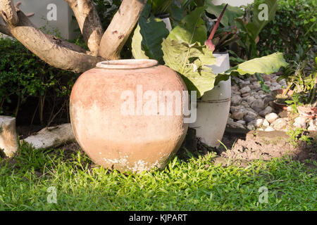 Irdenen Krug in den Garten, irdenen Wasserkrug, Garten Requisiten, alten Thai Gläser für die Lagerung von Regenwasser Stockfoto