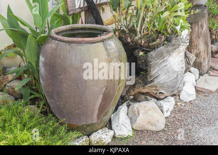 Irdenen Krug in den Garten, irdenen Wasserkrug, Garten Requisiten, alten Thai Gläser für die Lagerung von Regenwasser Stockfoto