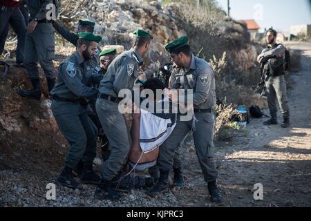 Netiv Ha'avot, Jerusalem. November 2017. Die israelische Polizei schuftet mit jüdischen Siedlern während der Evakuierung eines Gebäudes in Netiv Ha'avot, südlich von Jerusalem, am 29. November 2017. Israelische Sicherheitskräfte haben am Mittwoch eine illegal gebaute Tischlerei in einem jüdischen Außenposten im Westjordanland abgerissen, als Dutzende von Siedlern den Ort versammelten, um gegen den Abriss zu protestieren. Quelle: JINI/Xinhua/Alamy Live News Stockfoto