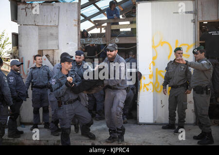 Netiv Ha'avot, Jerusalem. November 2017. Die israelische Polizei schuftet mit jüdischen Siedlern während der Evakuierung eines Gebäudes in Netiv Ha'avot, südlich von Jerusalem, am 29. November 2017. Israelische Sicherheitskräfte haben am Mittwoch eine illegal gebaute Tischlerei in einem jüdischen Außenposten im Westjordanland abgerissen, als Dutzende von Siedlern den Ort versammelten, um gegen den Abriss zu protestieren. Quelle: JINI/Xinhua/Alamy Live News Stockfoto