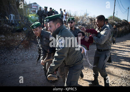 Netiv Ha'avot, Jerusalem. November 2017. Die israelische Polizei schuftet mit jüdischen Siedlern während der Evakuierung eines Gebäudes in Netiv Ha'avot, südlich von Jerusalem, am 29. November 2017. Israelische Sicherheitskräfte haben am Mittwoch eine illegal gebaute Tischlerei in einem jüdischen Außenposten im Westjordanland abgerissen, als Dutzende von Siedlern den Ort versammelten, um gegen den Abriss zu protestieren. Quelle: JINI/Xinhua/Alamy Live News Stockfoto