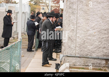 NEW YORK, NY - 25. NOVEMBER: Chabad-lubawitsch Rabbis beten am Grab der Lubavitcher Rebbe, Rabbi Menachem M. Scheerson, 4.550 Rabbiner aus der ganzen Welt sind in New York für die Internationale Konferenz der Chabad-Lubavitch Abgesandte, eine jährliche Veranstaltung zur Wiederbelebung jüdischen Bewusstsein und Praxis auf der ganzen Welt ausgerichtet. In diesem Jahr wird das 75. Jahr seit Rabbi Menachem M. Schneerson, des seligen Gedächtnis, die Bewegungen auf dem Gebiet der US-Ufer vom Krieg angekommen - Europa 1941 Am 25. November 2016 in Queens Borough von New York Menschen zerrissen: Chabad-lubawitsch Rabbiner Stockfoto