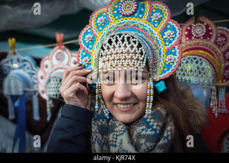 Nette und schöne Mädchen in warmen und Wolle Schal lächelnd und stand im City Markt in nationalen traditionelle Kopfbedeckung im Winter Stockfoto