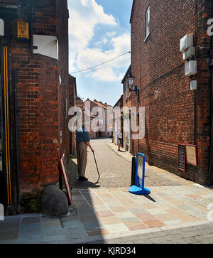 Mann an der Ecke des traditionellen Fußgängerzone gepflasterten Straße, Beverley, East Yorkshire, Großbritannien Stockfoto