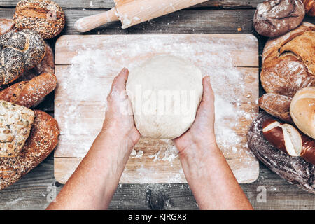 Baker Vorbereitung eine Vielzahl leckeres frisches Brot und Gebäck Stockfoto