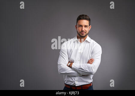 Ein schöner selbstbewussten jungen Mann und lächelnd in einem weißen Hemd. Stockfoto