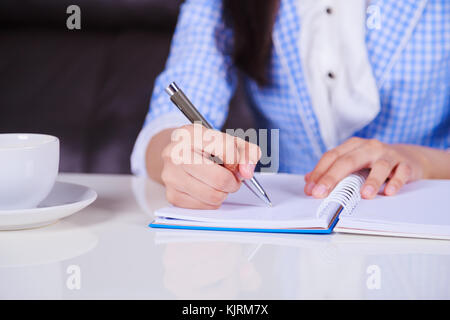 Nahaufnahme der Hand schreiben auf Notebook Stockfoto