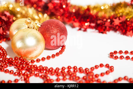 Weihnachtsschmuck aus roten und goldenen Farbe auf weißem Hintergrund - Kugeln, Perlen und Flitter Stockfoto