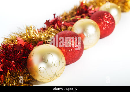 Weihnachtsschmuck ofred und goldene Farbe auf weißem Hintergrund - Kugeln und Lametta Stockfoto