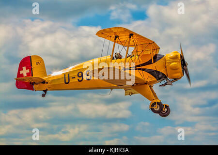 Claudio Coltri schießt in Wickenby in seiner BückerJungmeister G-AXMT über, das Flugzeug wurde in seiner Schweizer Luftwaffe Lackierung als U-99 restauriert. Stockfoto