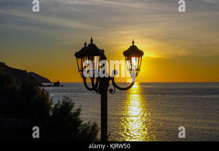 Leuchter mit drei Leds gegen die untergehende Sonne silhouetted, Kalymnos, Griechenland Stockfoto