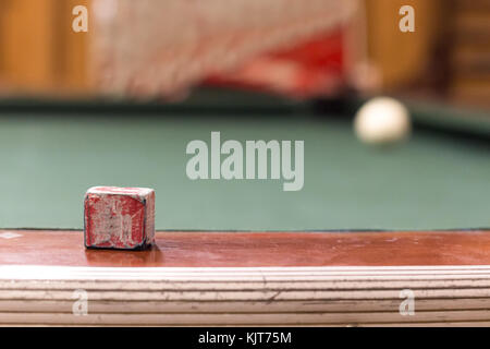 Ein Pool verwendet Kreide an der Seite eines alten Pool Tisch gestellt mit der weißen Kugel an der Ecke als Hintergrund. Stockfoto