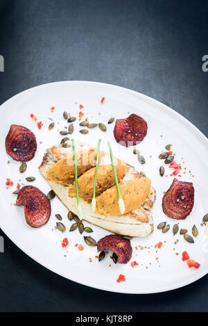 Gourmet Fisch Filet mit Kichererbsen curry Kartoffelpüree und Rote Beete chips Mahlzeit Stockfoto