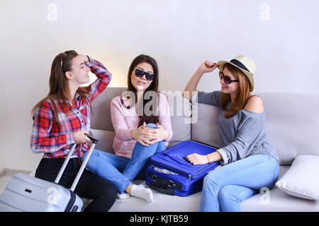 Nette Mädchen gehen auf Reise und die Vorbereitung der Koffer auf der Couch im aft Stockfoto