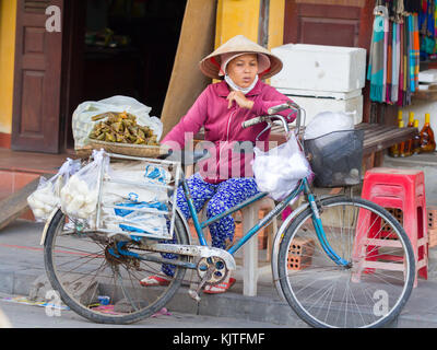 Saigon, Vietnam - Juni 2017: vietnamesin in konischer Hut mit Fahrrad, Saigon, Vietnam. Stockfoto