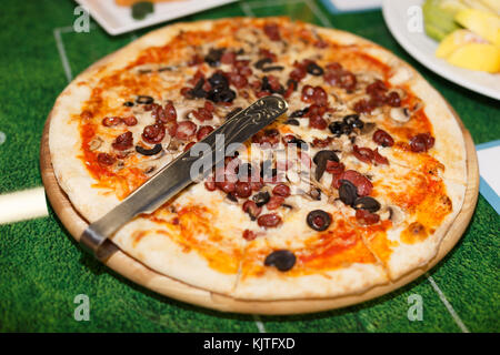 Pizza mit Oliven auf der Platte ganz nah Stockfoto
