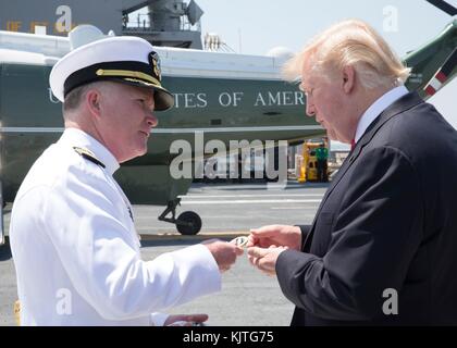 Richard McCormack überreicht US-Präsident Donald Trump nach der Zeremonie der Inbetriebnahme des Flugzeugträgers der US-Navy Gerald R. Ford auf der Marinestützpunkt Norfolk am 22. Juli 2017 in Norfolk, Virginia, eine Münze. (Foto: MCS3 Matthew R. Fairchild via Planetpix) Stockfoto