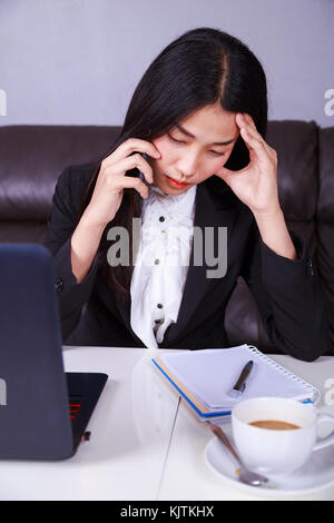 Frau in Business Anzug im Stress verzweifelt auf ein Handy arbeiten Stockfoto
