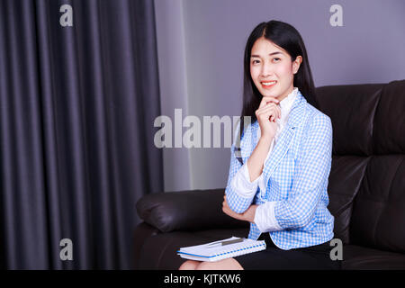 Young Business Frau sitzt auf einem Sofa Stockfoto