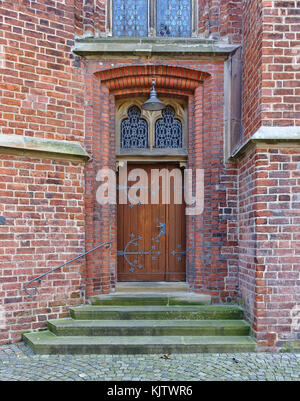 Alte Holztür in der Wand mit Beschläge, Schritte und verzierten Fenstern Stockfoto