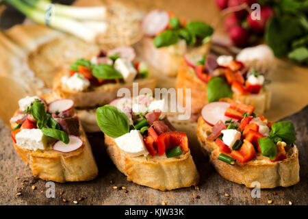 Traditionelle italienische Bruschetta mit Käse und Gemüse. selektive Fokus auf Bruschetta in der Mitte Stockfoto