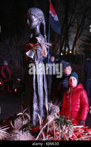 Kiew, Ukraine. November 2017. Das Mädchen steht neben einem Denkmal für die Opfer der großen Hungersnot in Kiew, Ukraine, 25. November 2017. Der Holodomor war eine von Menschenhand geschaffene Hungersnot, die von den sowjetischen Behörden unter der Führung des Diktators Joseph Stalin provoziert wurde. Das Ergebnis war der Tod von mehr als fünf Millionen Ukrainern. Anatolii Stepanov/ZUMA Wire/Alamy Live News Stockfoto