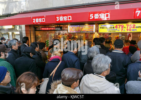 Am ersten Verkaufstag der Jumbo-Lotterie am 27. November 2017 in Tokio, Japan, werden Lottoscheine gekauft. Schon am frühen Morgen reisten Käufer an, um ihre Lottoscheine am ersten Ticketschalter in Ginza zu kaufen, das für seine großen Gewinner bekannt ist. Der diesjährige Hauptpreis beträgt 1 Milliarde Yen (ca. 8,9 Millionen US-Dollar) und jedes Ticket kostet 300 Yen (2,69 US-Dollar). Der Ticketverkauf wird landesweit bis zum 22. Dezember fortgesetzt. Quelle: Rodrigo Reyes Marin/AFLO/Alamy Live News Stockfoto