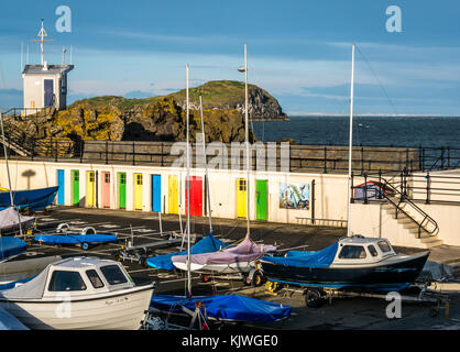 North Berwick, East Lothian, Schottland, Großbritannien, 27. November 2017. Die Küstenstadt North Berwick an einem hellen sonnigen kalten Herbstmorgen. Blick über den Firth of Forth auf die Craigleith Insel, mit Segelbooten und Schlauchbooten im Hafen des East Lothian Yacht Club, der früher als Ort eines Außenpools mit bunten Türen der alten Umkleidekabinen genutzt wurde Stockfoto