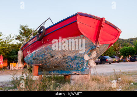 Unkraut überwuchert, alte hölzerne Fischerboot trocken angedockt, zum Strand zurückgezogen. Stockfoto