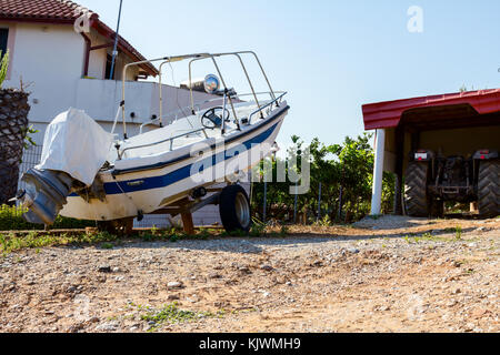 Kleines Motorboot ist trocken angedockt auf dem Anhänger für den Transport Boote im Hinterhof. Stockfoto