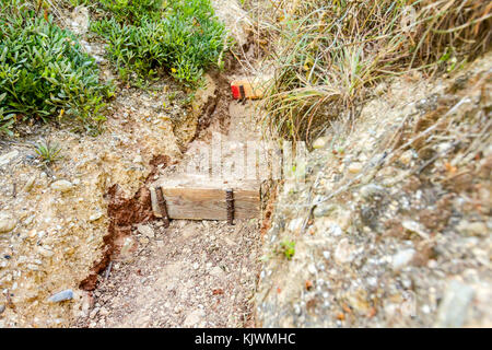 Schmale Passage durch den Korridor in Rock mit geschnitzten Treppe. Stockfoto