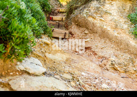 Schmale Passage durch den Korridor in Rock mit geschnitzten Treppe. Stockfoto