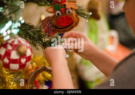 Die Dekoration der Weihnachtsbaum ist eine jährliche Tradition, dass sich die ganze Familie mit einbezogen wird. Stockfoto