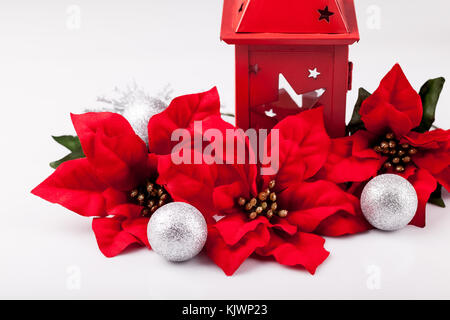 Weihnachtsdekoration, Roter Weihnachtsstern und silbernen Kugeln auf einem weißen Hintergrund. Stockfoto