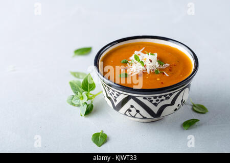 Pürierte Tomaten Suppe in einer Schüssel garniert mit Käse und Basilikum Stockfoto