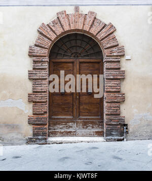 Massiv Türen typisch für Süditalien. Hölzerne Tür in einer alten Steinmauer. Alte vintage Türen. Alte Holztür in einem Steinhaus in Italienisch Stockfoto