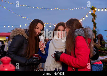 Drei junge Frau Fotos auf Weihnachtsmarkt Stockfoto