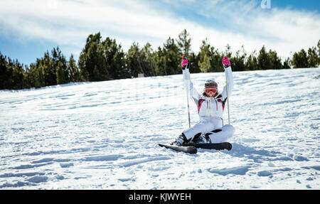 Schöne junge Frau genießen und Spaß auf Ski Urlaub. Sie sitzt mit Skiern und Kamera mit Lächeln. Stockfoto
