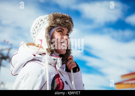 Schöne junge Frau genießen im Skiurlaub. Sie an sonnigen Wintertag posing und Wegsehen mit Lächeln. Stockfoto