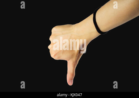 Schöne weibliche Hand Daumen nach unten auf schwarzem Hintergrund isoliert, asiatische, gelbe Haut. Stockfoto