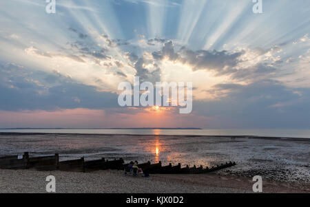 Sonnenstrahlen über Whitstable Beach und der Insel Sheppey. Stockfoto